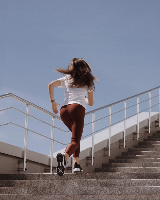 The image shows a girl running up the stairs